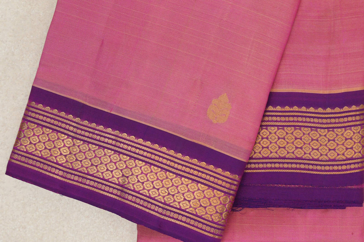 Folded rose pink lightweight Kanchipuram silk saree with a small gold leaf motif and purple borders patterned in gold.