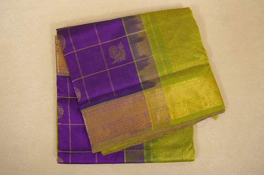 Purple and green traditional fabric with a checkered pattern on a beige background, folded