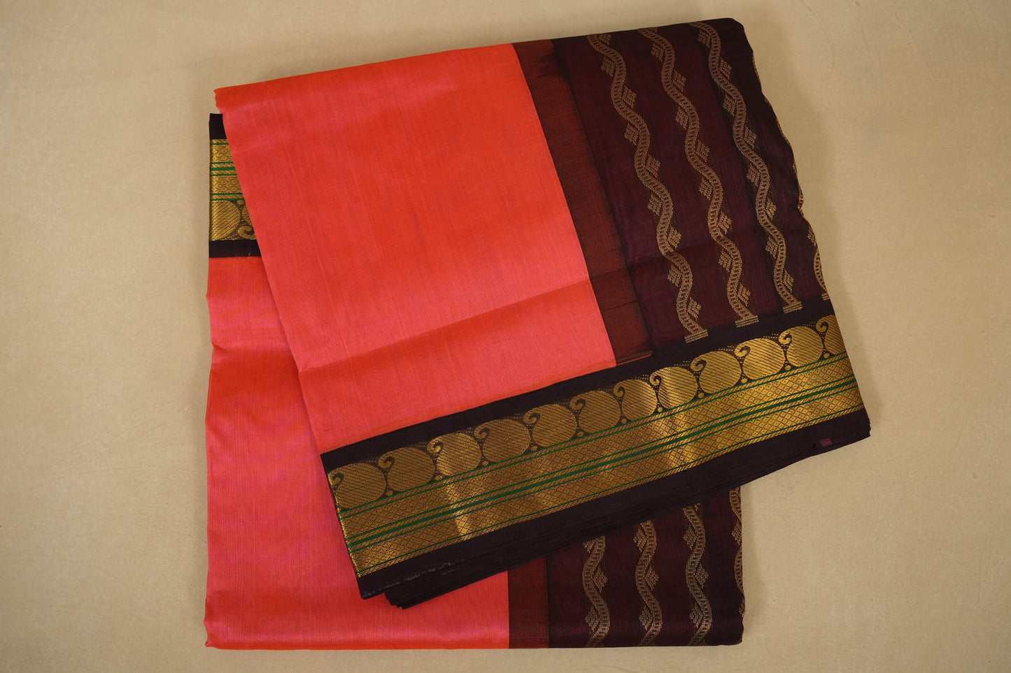 Peach pink and black saree with gold border on a beige background, silk cotton , nine and a half yards saree folded