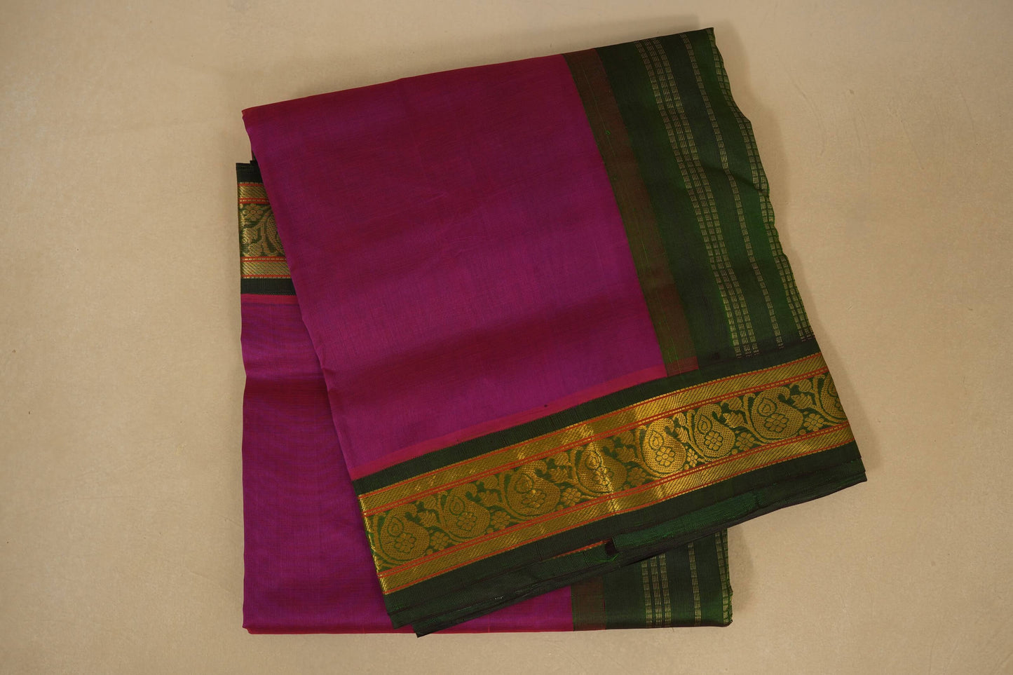Purple saree with green and gold border on a beige background, silk cotton , nine and a half yards saree folded