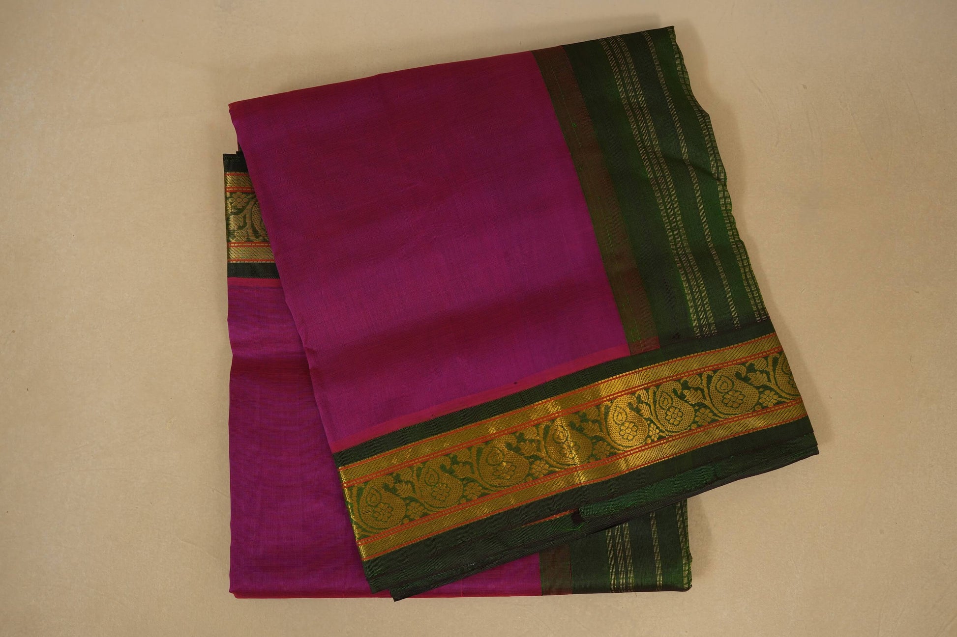 Purple saree with green and gold border on a beige background, silk cotton , nine and a half yards saree folded