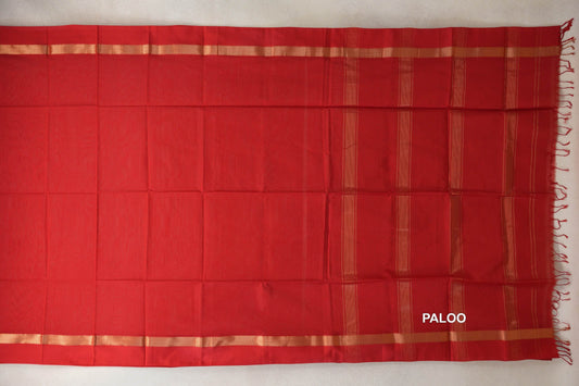 Vermilion Red Maheshwari silk cotton saree spread flat, with a plain body, gold-toned border bands and a striped pallu with tassels at the right.