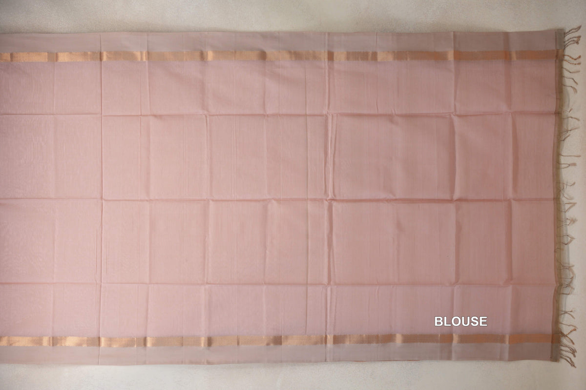 Blush pink Maheshwari silk cotton blouse piece laid flat, with light sandal beige borders along both long edges and tassels at one end.