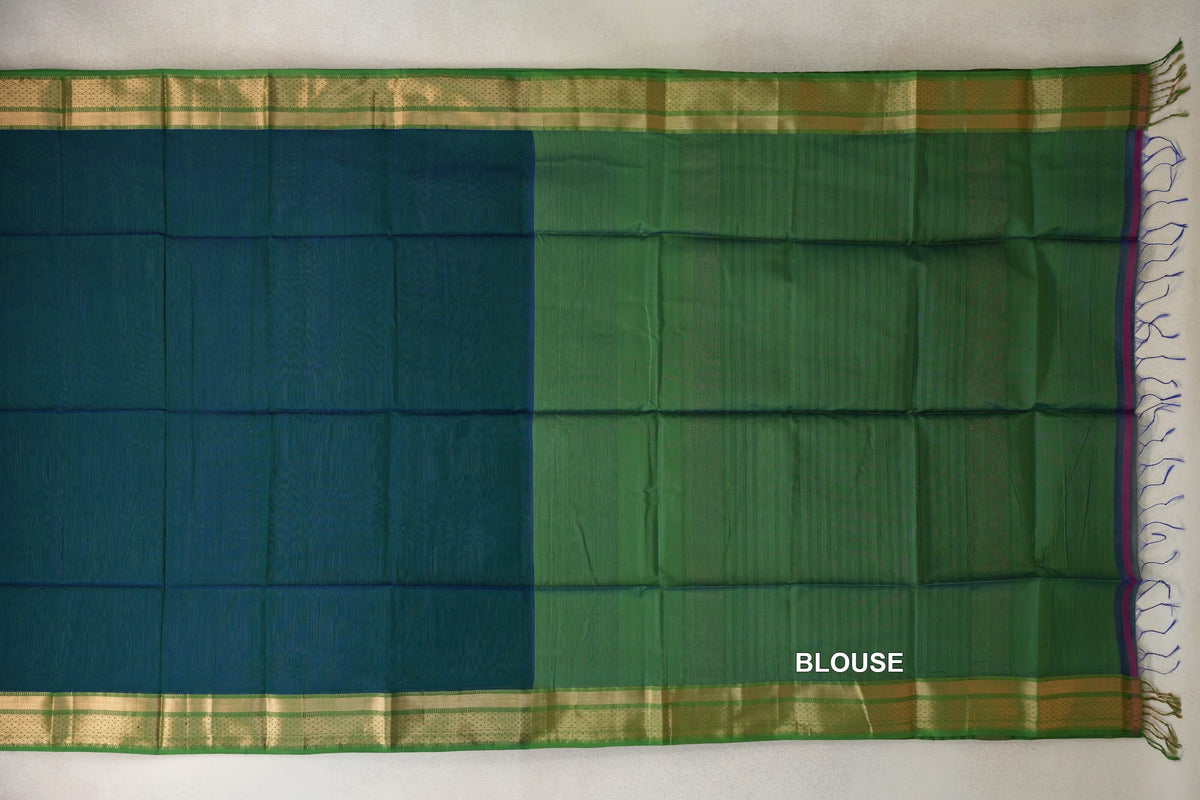 Maheshwari silk cotton saree laid flat, with a peacock blue body, leaf green blouse piece, gold-toned borders and tassels.