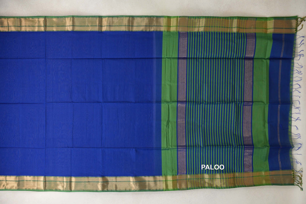 Maheshwari silk cotton saree spread flat, with a bright royal blue body, leaf green borders and a blue-and-green striped pallu.