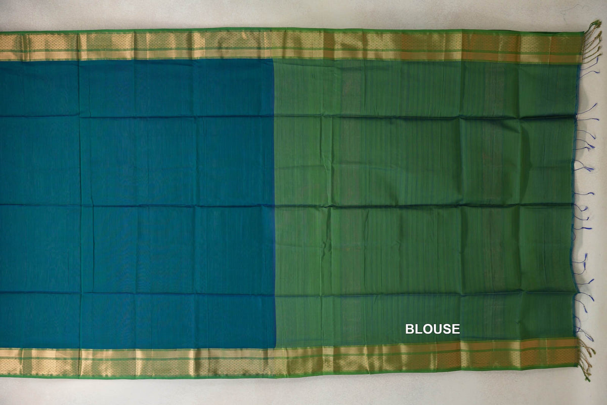 Maheshwari silk cotton saree laid flat, showing a bright royal blue pallu beside a leaf green blouse piece, with gold-patterned borders and tassels.