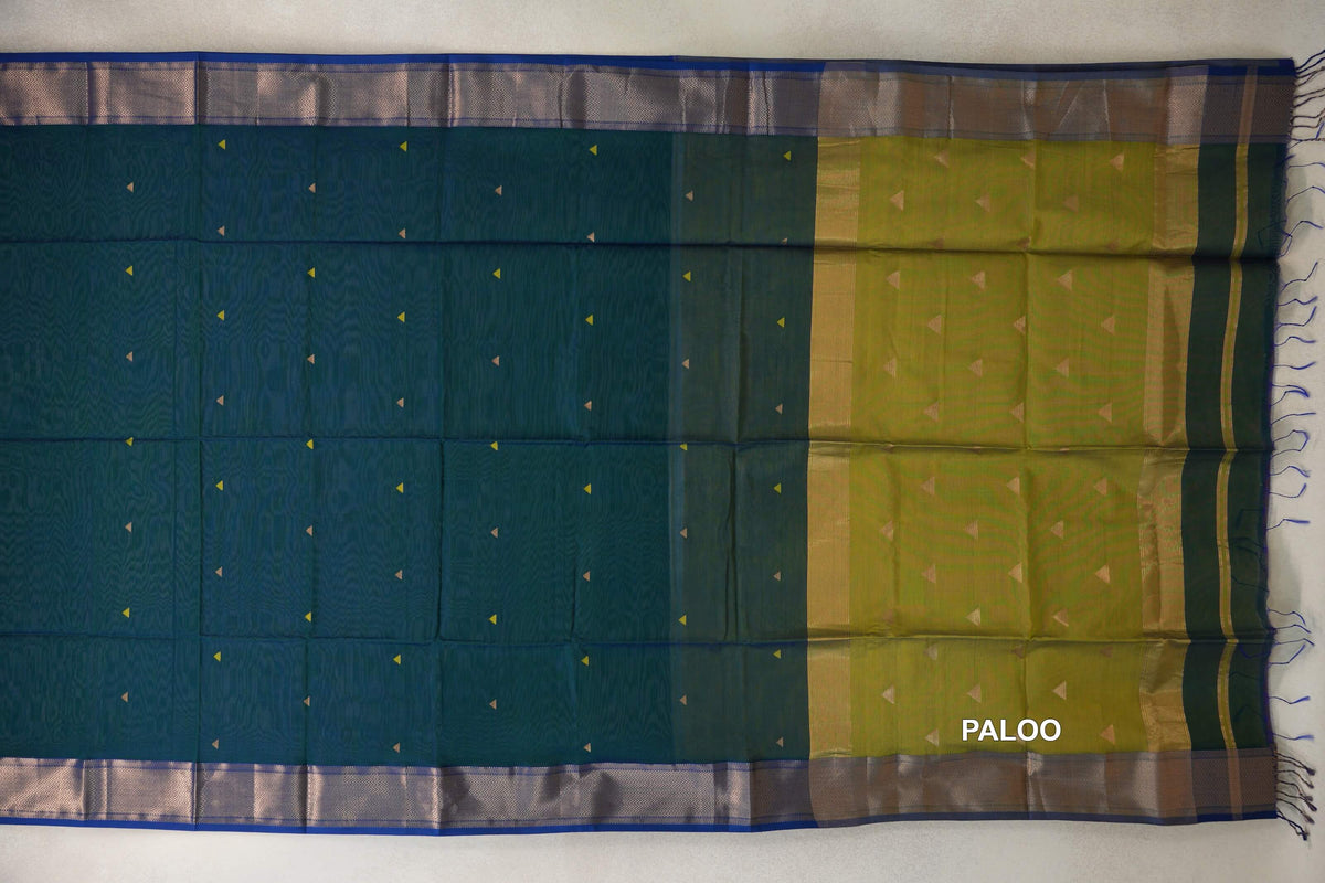 Maheshwari silk cotton saree spread flat, showing a peacock green body with small triangle motifs, a mehandi green pallu, royal blue borders and tassels.