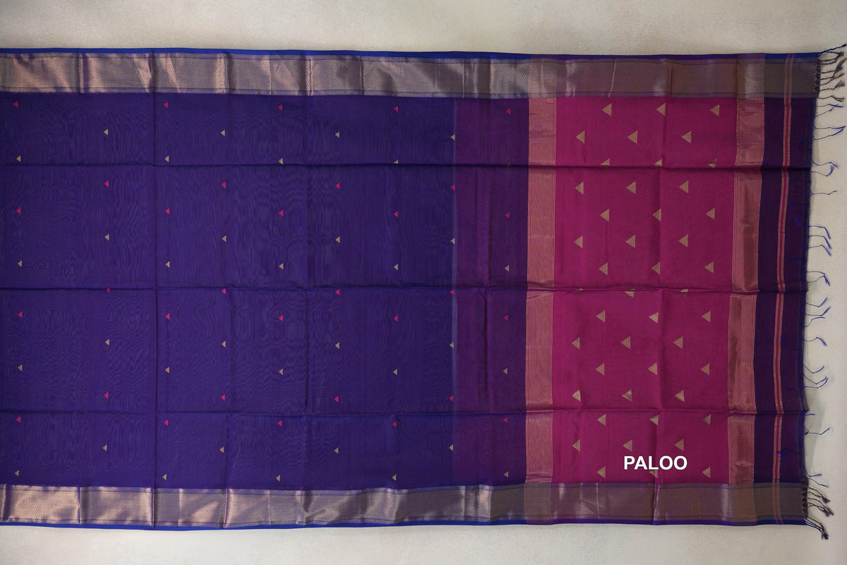 Deep violet Maheshwari silk cotton saree laid flat, with small triangle motifs, zigzag-patterned borders and a deep rani pink pallu with tassels.