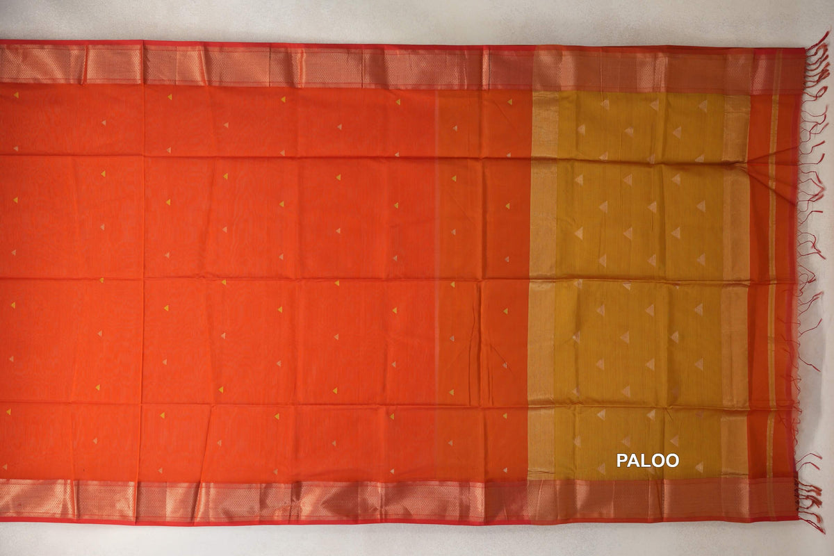 Maheshwari silk cotton saree laid flat, with a reddish orange body dotted with small triangles, patterned orangish red borders and a lime yellow pallu.