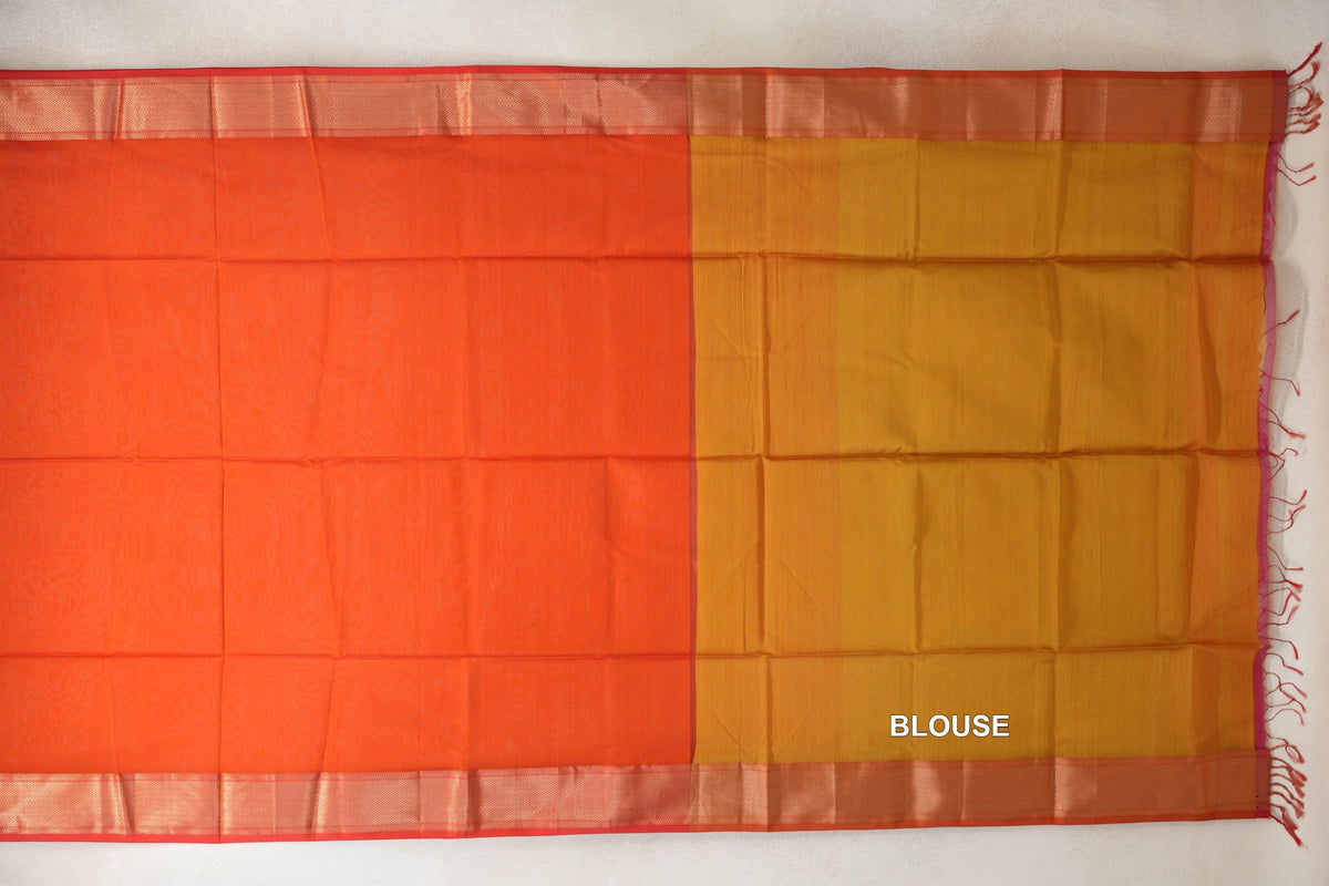 Laid-flat Maheshwari silk cotton saree showing a reddish orange body, lime yellow blouse section, patterned orangish red borders and tassels.