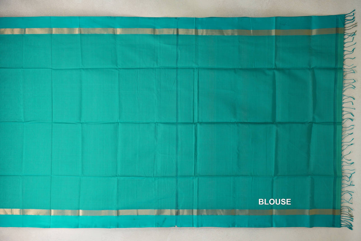 Bright aqua green Maheshwari silk cotton saree blouse section laid flat, with narrow gold-toned borders and tassels along one edge.