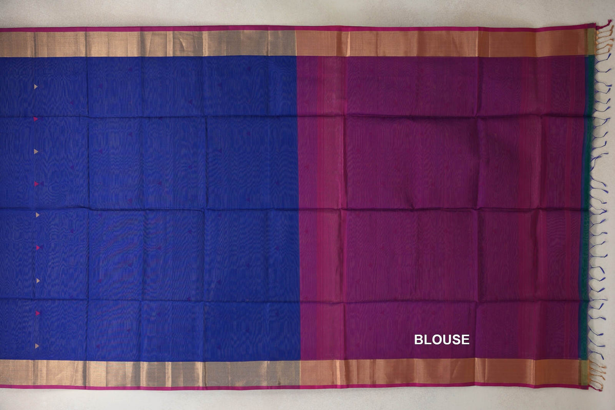Maheshwari silk cotton saree laid flat, showing a bright royal blue body beside a rani pink blouse piece, with gold-toned borders and tassels.