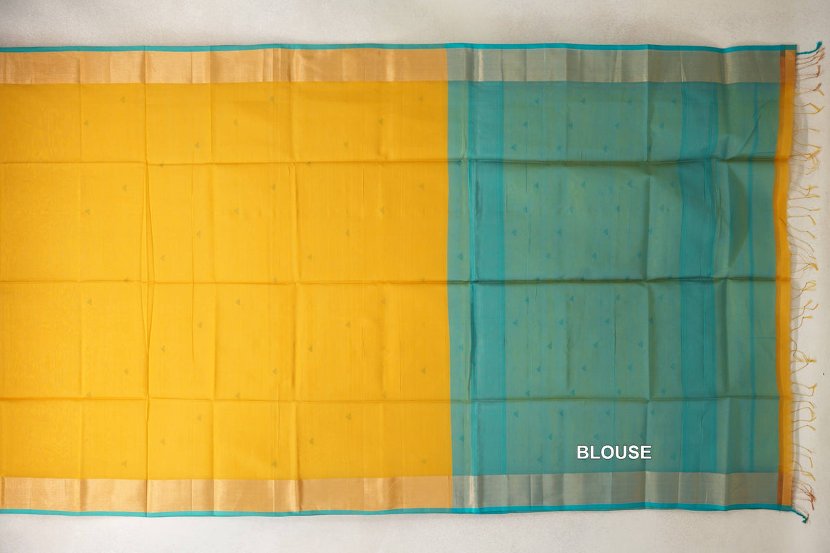 Maheshwari silk cotton saree laid out with a mustard yellow body, small triangular motifs, pale gold borders and a turquoise blue blouse piece at right.