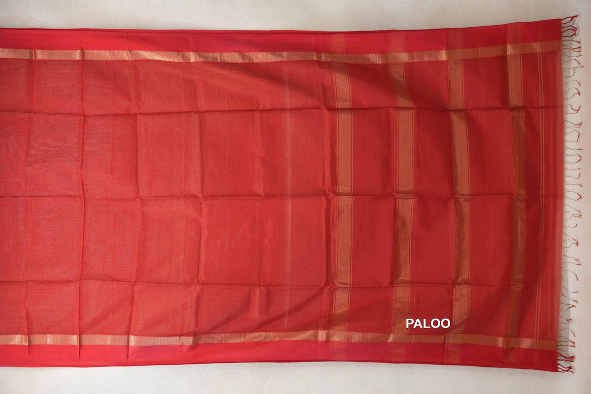 Tomato red Maheshwari silk cotton saree laid open, showing a plain body, gold-toned striped pallu, narrow borders and red fringe.