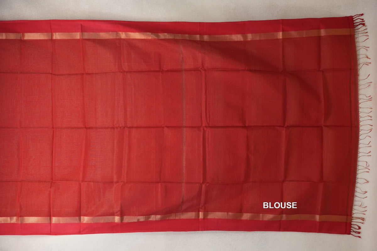 Tomato red Maheshwari silk cotton blouse piece laid flat, with narrow gold-toned borders and fringe along one edge.