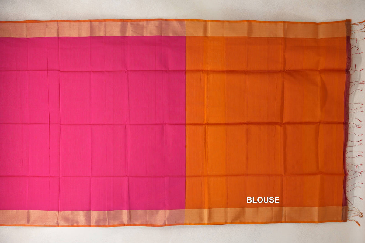 Maheshwari silk cotton saree laid flat, showing a plain Rani Pink body, orange borders and an orange blouse piece with fringe at the edge.
