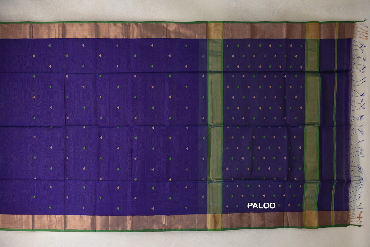 Spread-out Maheshwari silk cotton saree with a deep violet body and pallu, small green and pale triangles, green bands, wide borders and tassels.