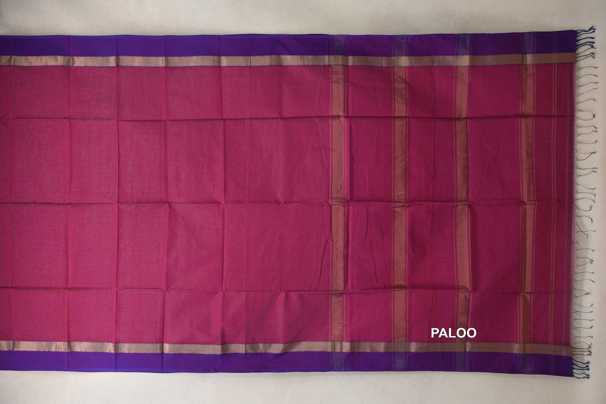 Deep rani pink Maheshwari silk cotton saree laid flat, showing a striped pallu, violet purple borders with metallic-looking bands, and end tassels.