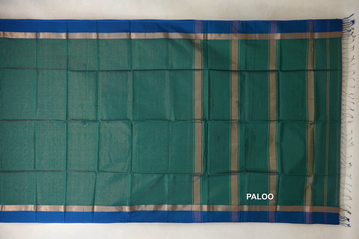 Bottle green Maheshwari silk cotton saree spread flat, with peacock blue borders, metallic bands and a striped pallu with tassels.