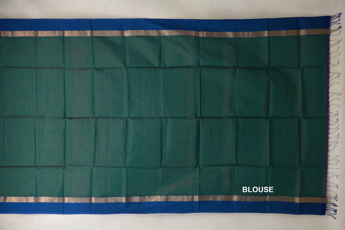 Bottle green Maheshwari silk cotton blouse piece laid flat, with peacock blue borders, narrow metallic bands and tassels at one end.