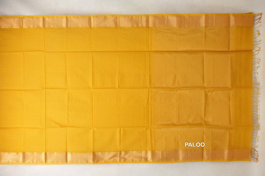 Mustard yellow Maheshwari silk cotton saree laid flat, showing a plain body, lustrous matching borders and a pallu with tassels at the right edge.