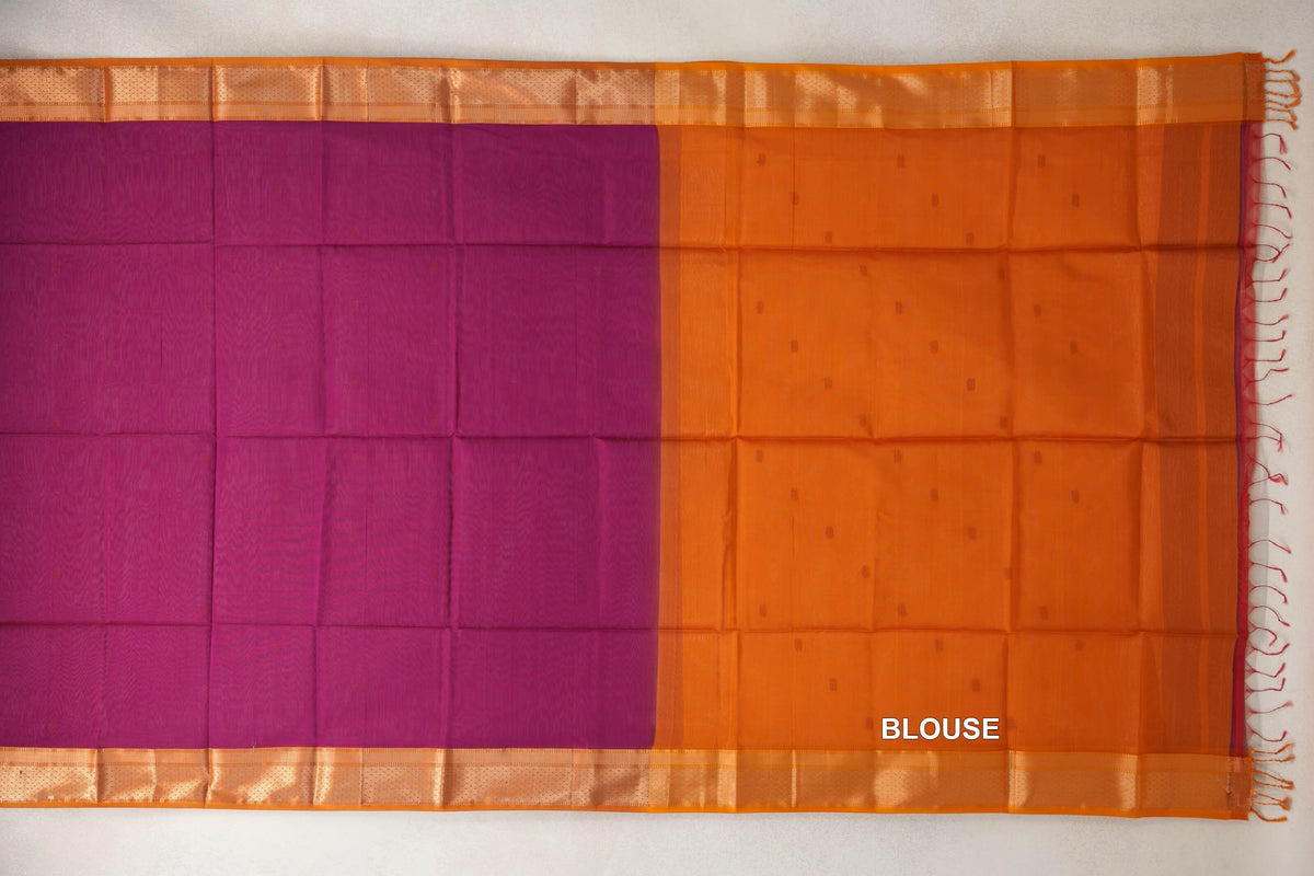 Maheshwari silk cotton saree laid flat, showing a dark magenta body, deep orange blouse section, patterned borders and tassels.