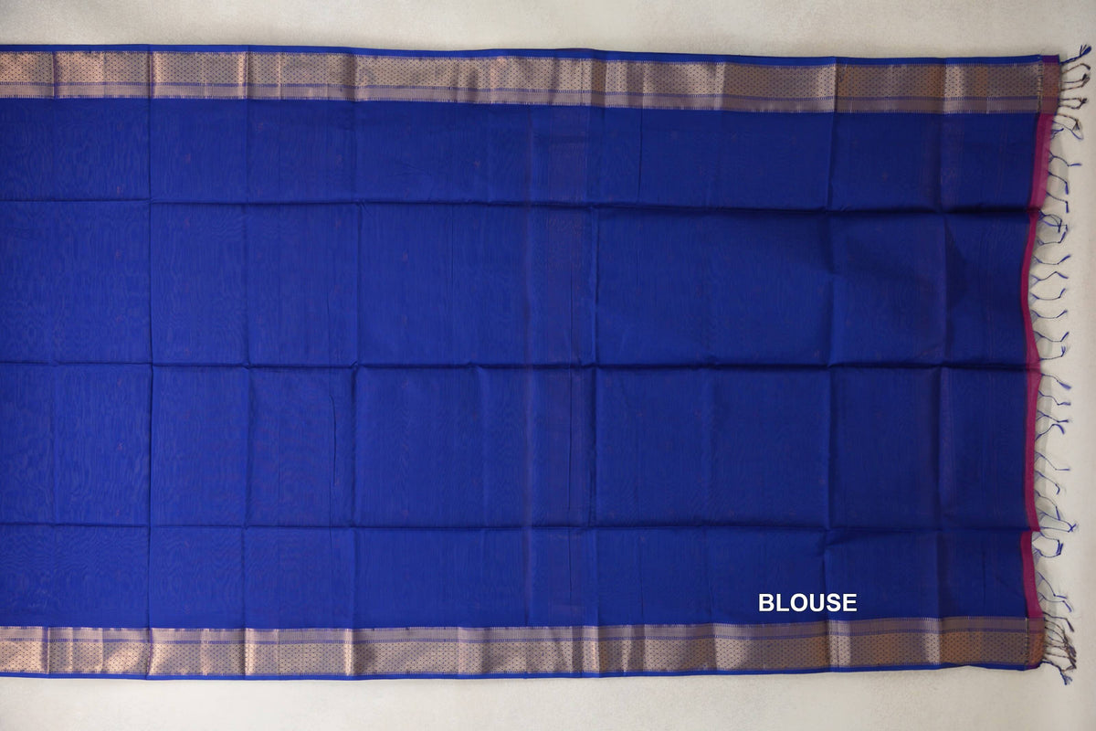 Bright royal blue Maheshwari silk cotton blouse piece laid flat, with pale patterned borders along the top and bottom and tassels at one end.