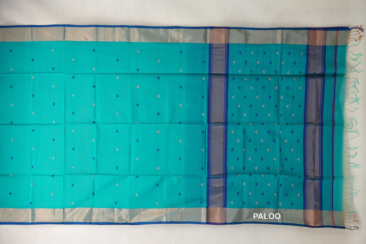 Maheshwari silk cotton saree laid flat, with a bright turquoise green body, small triangular motifs, blue-edged borders and a striped pallu with tassels.