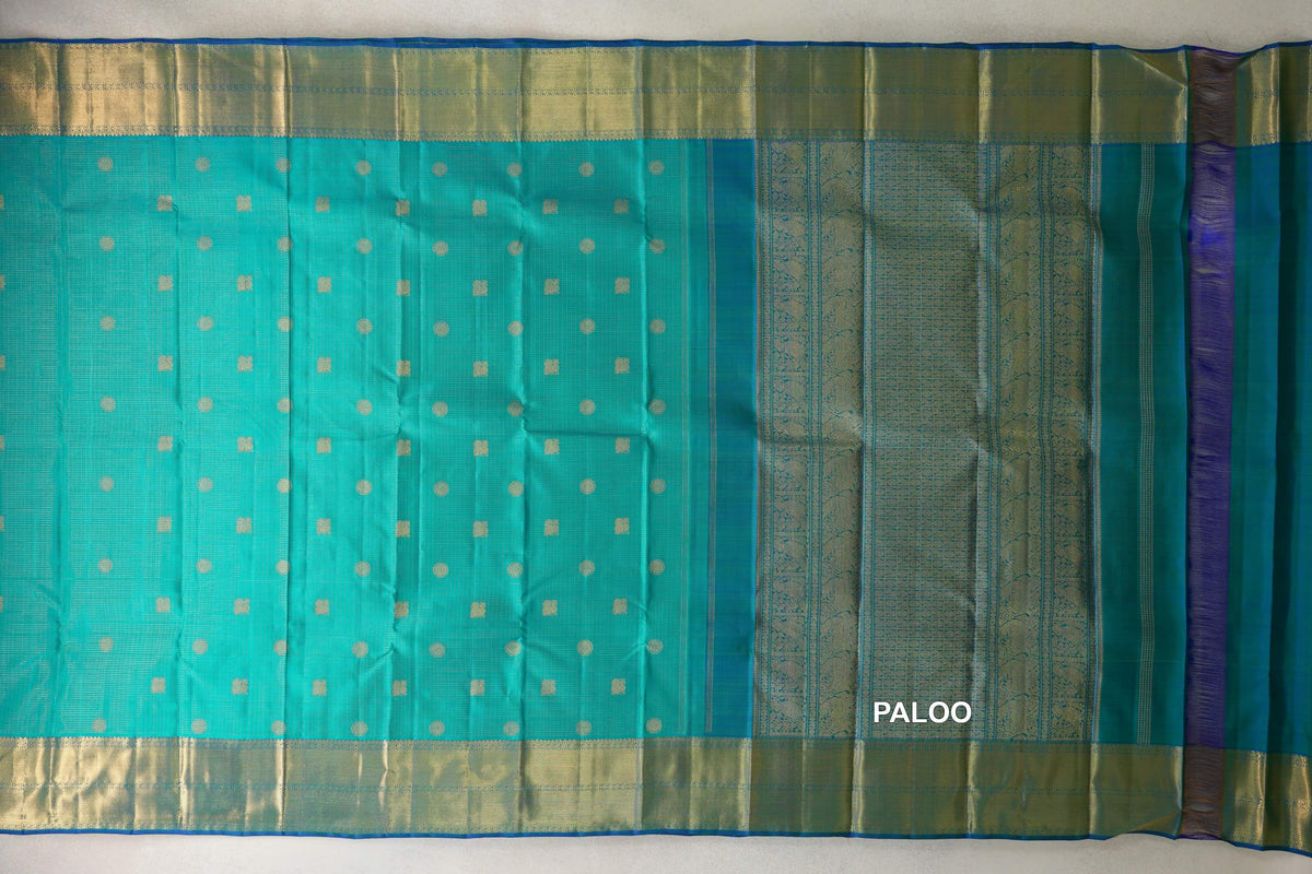 Aqua Green heirloom Kanjivaram silk saree spread open, with gold-toned dot and square motifs, broad borders and an ornate pallu.