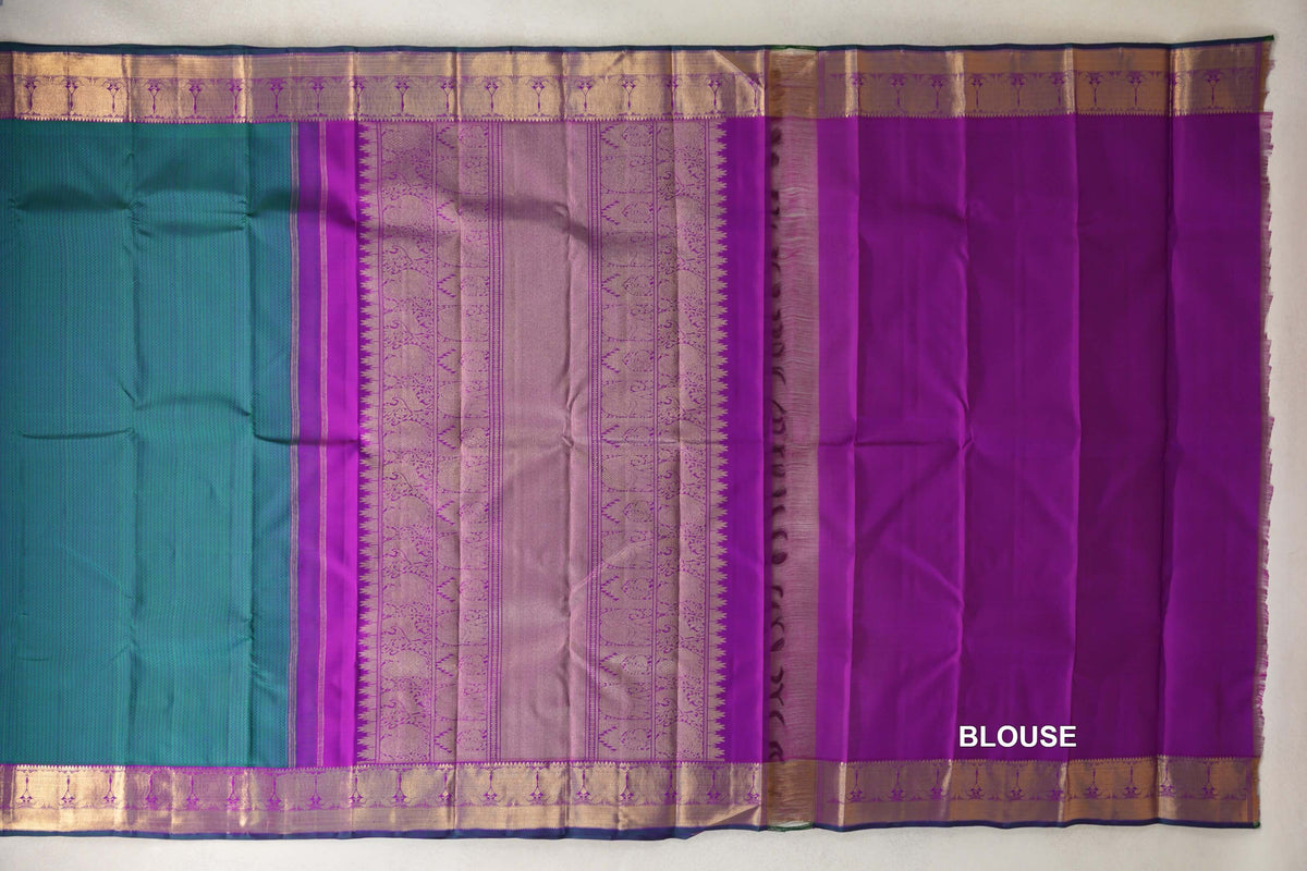 Kanjivaram silk saree laid out with a peacock green body, patterned purple pallu, gold-toned borders and a plain purple blouse piece.
