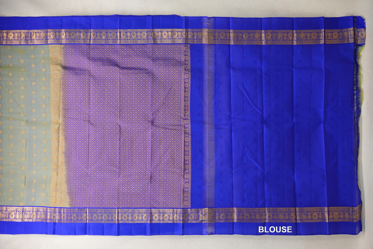 Laid-flat light weight Kanchipuram silk saree showing a yellowish green dotted body, gold lattice pallu, royal blue patterned borders and matching blouse fabric.