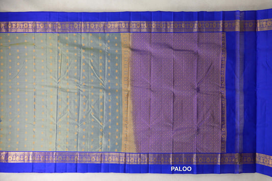 Spread-out light weight Kanchipuram silk saree with a yellowish green body, gold dots, royal blue patterned borders and a lattice-patterned pallu.