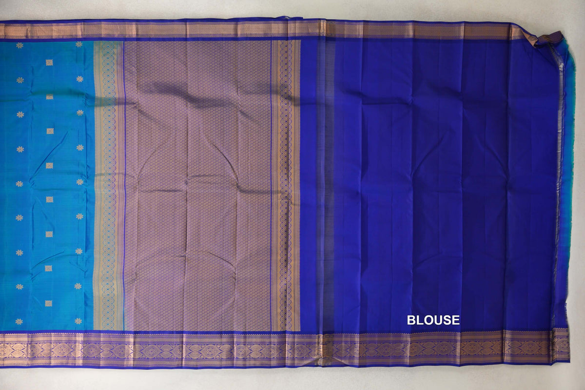 Spread-out Light Weight Kanchipuram silk saree with a peacock blue body, lattice-patterned pallu, deep royal blue blouse piece and ornate gold-toned borders.