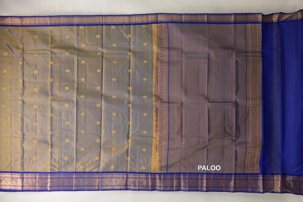 Unfolded light weight Kanchipuram silk saree with a yellow and violet body, small gold-toned motifs, deep royal blue borders and a patterned pallu.