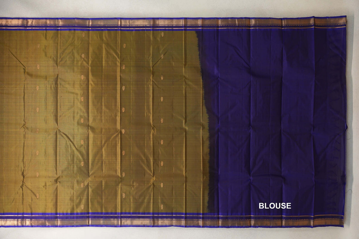 Light Weight Kanchipuram silk saree laid flat, with a dotted olive green body, deep royal blue and gold borders, and a blue blouse section on the right.