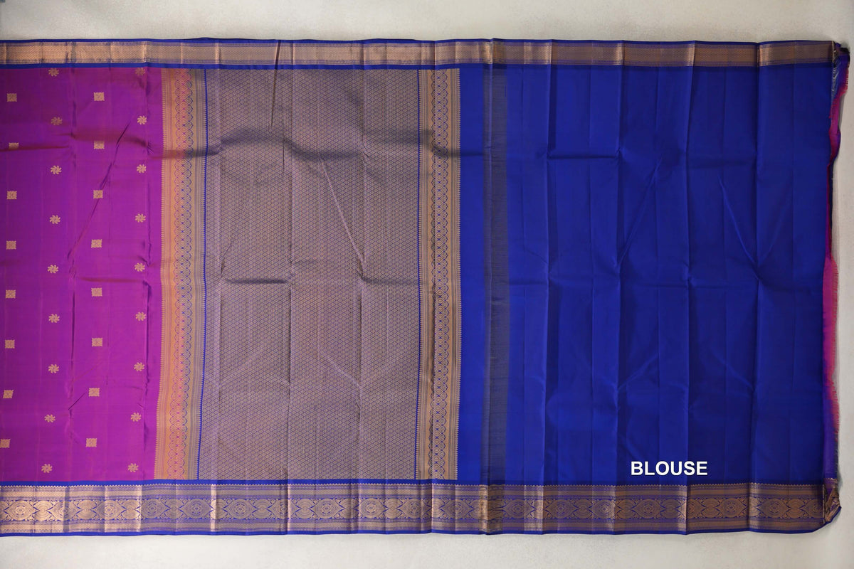 Lightweight Kanchipuram silk saree laid flat, with a rani pink body, lattice-patterned pallu, deep royal blue blouse piece and patterned borders.