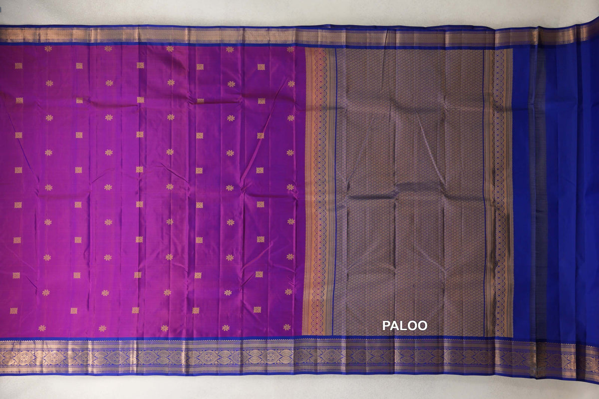Light Weight Kanchipuram silk saree spread out, showing a rani pink body with small gold motifs, deep royal blue borders and a patterned pallu.