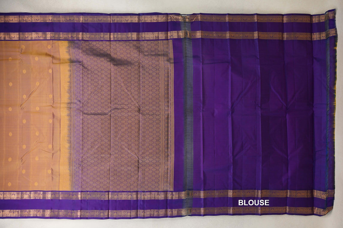 Laid-out mustard yellow Kanchipuram silk saree with small dots, deep purple patterned borders, a lattice-patterned pallu and a purple blouse piece.