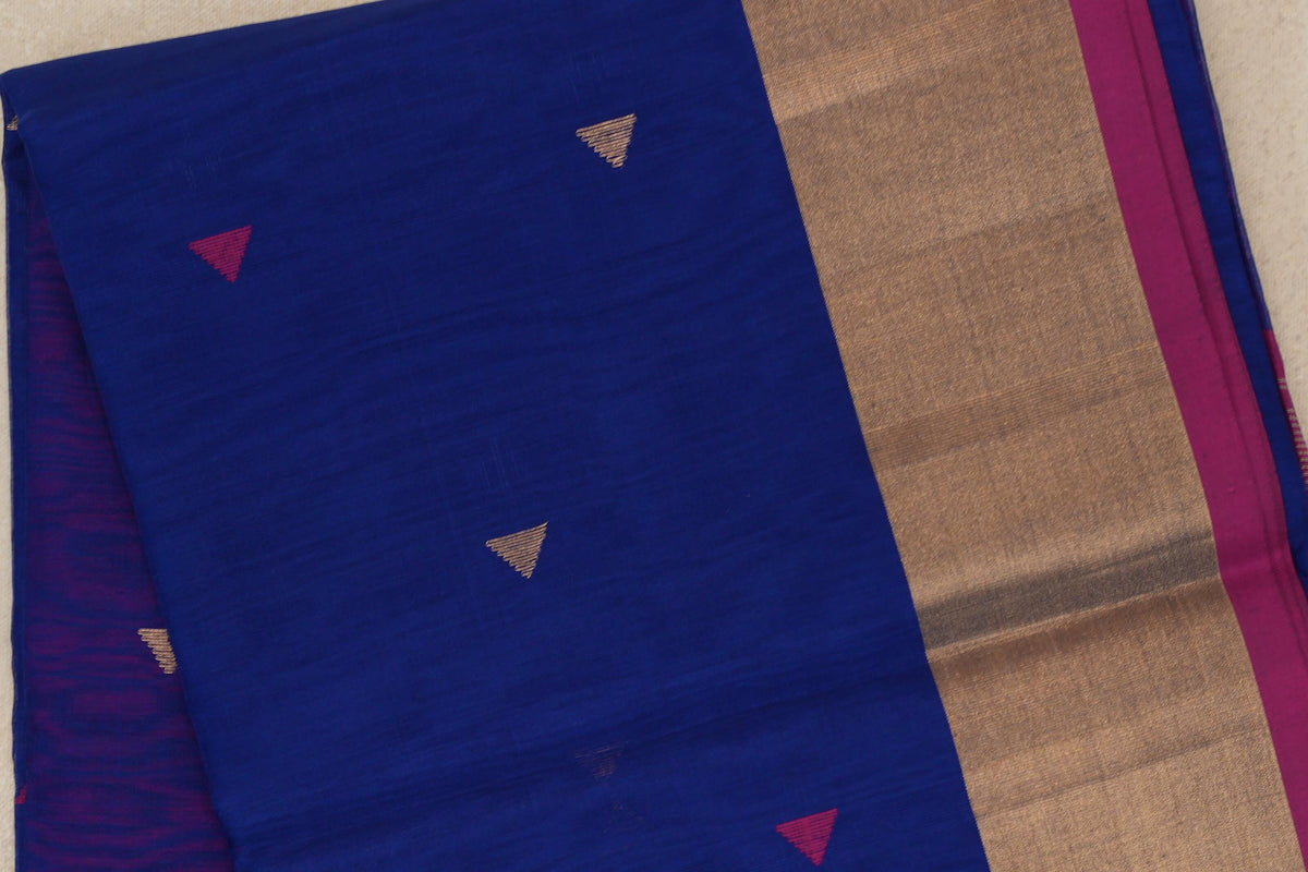 Folded bright royal blue Maheshwari silk cotton saree with small pink and gold triangles, a broad gold-toned border and rani pink edge.