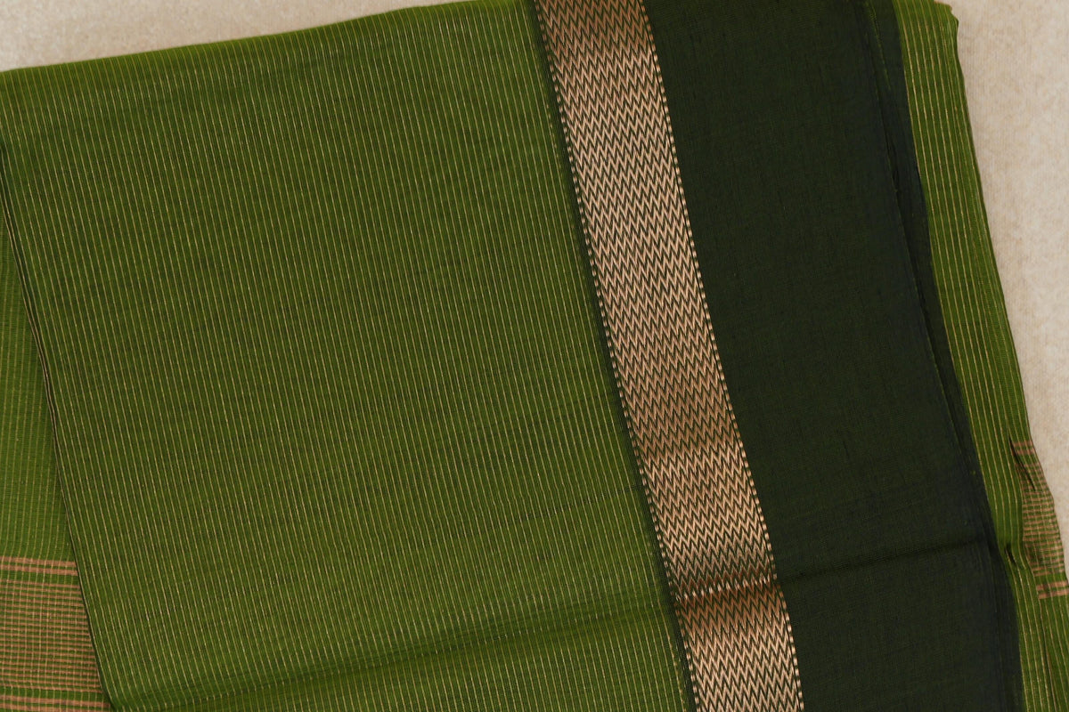 Folded Maheshwari silk cotton saree showing a finely striped olive green body, a patterned border band and a deep forest green panel.