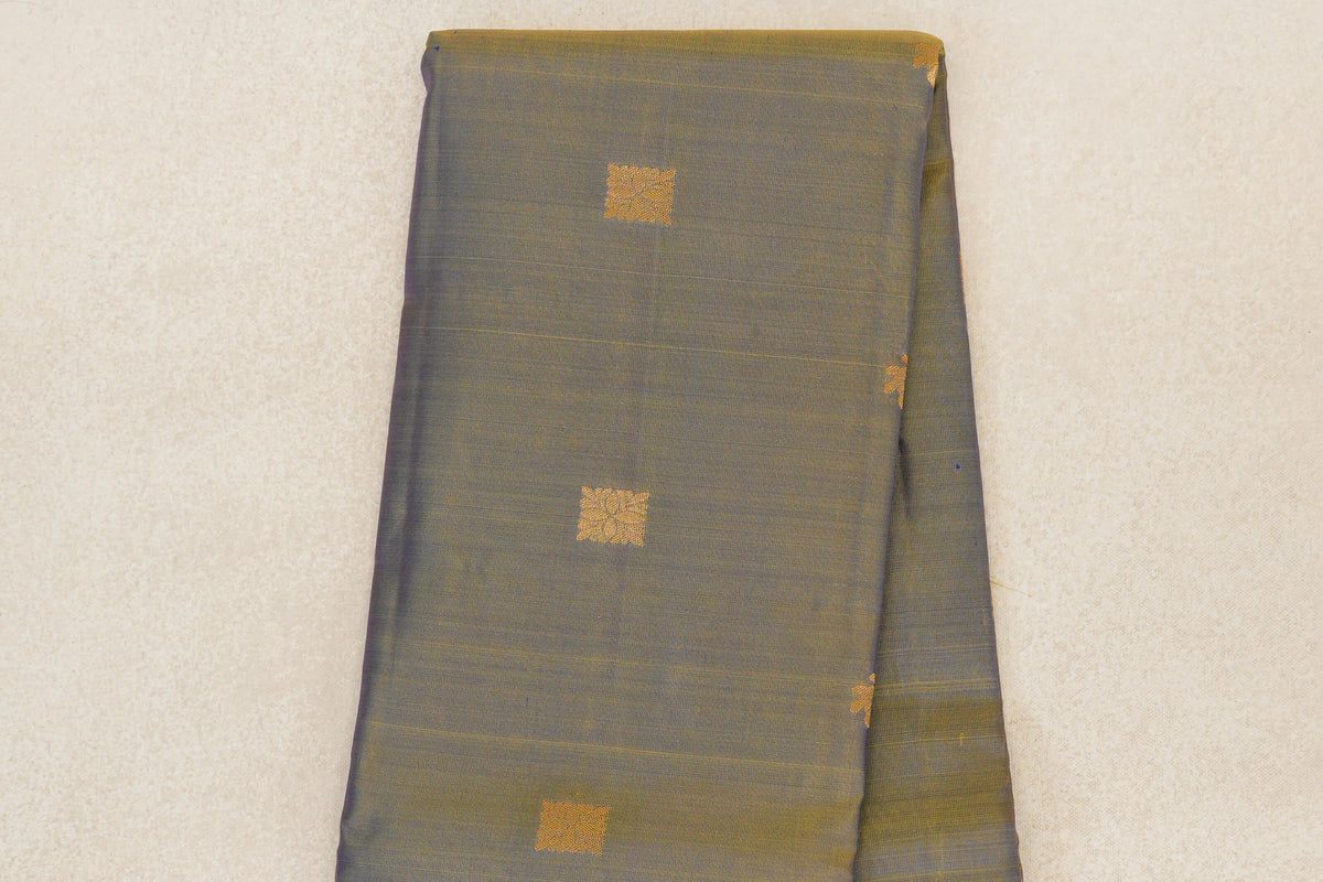 Folded light weight Kanchipuram silk saree showing a yellow and violet body with spaced gold square motifs and fine horizontal lines.