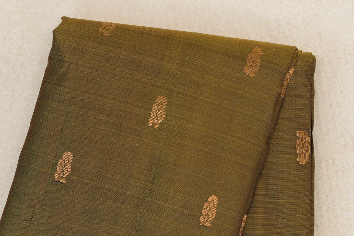 Folded olive green lightweight Kanchipuram silk saree body with small, spaced gold-toned woven motifs.