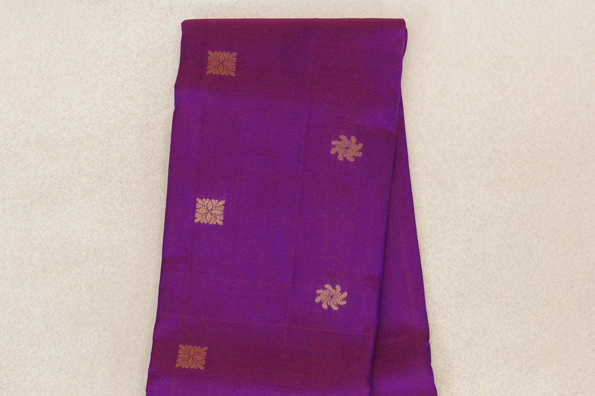 Folded lightweight Kanchipuram silk saree in blue and rani pink, with spaced gold square and floral motifs.