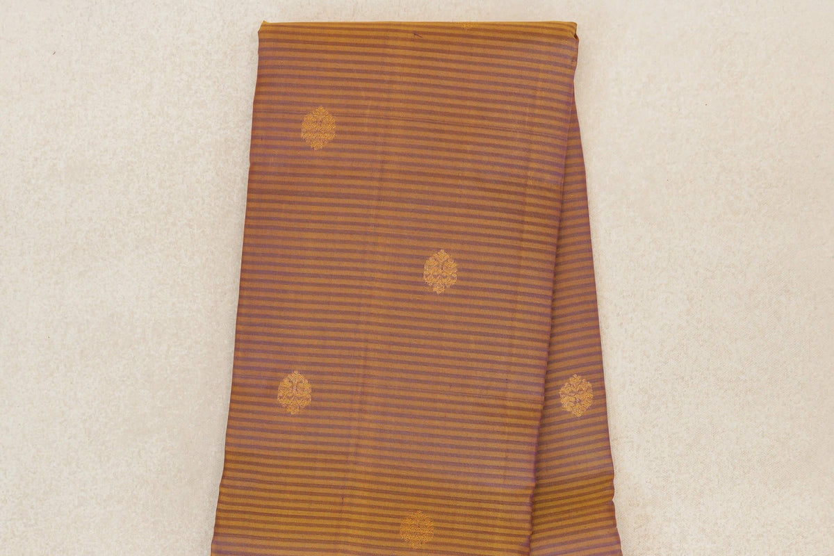 Folded Kanchipuram silk saree with fine mustard yellow and deep purple stripes and scattered mustard motifs.